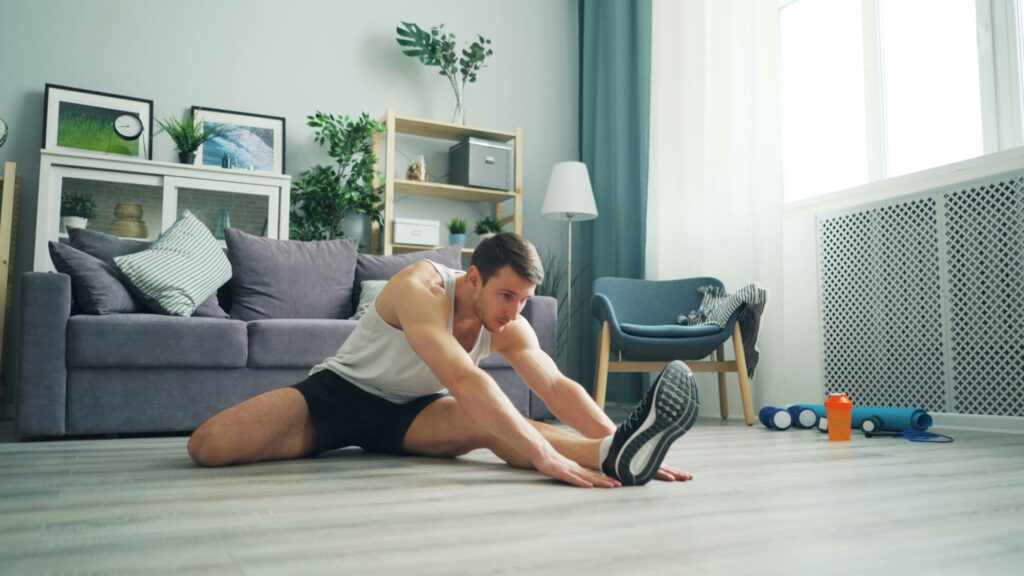 家でストレッチをしている男性