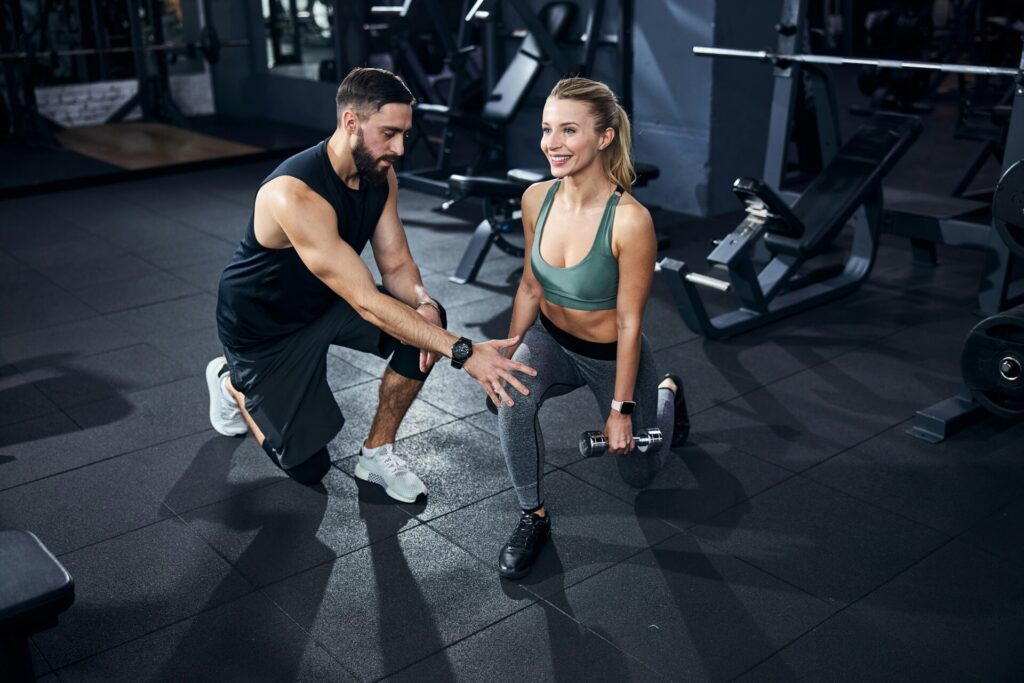 女性にパーソナルトレーニングをしている男性