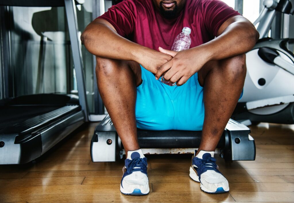 ジムで疲れて座っている男性