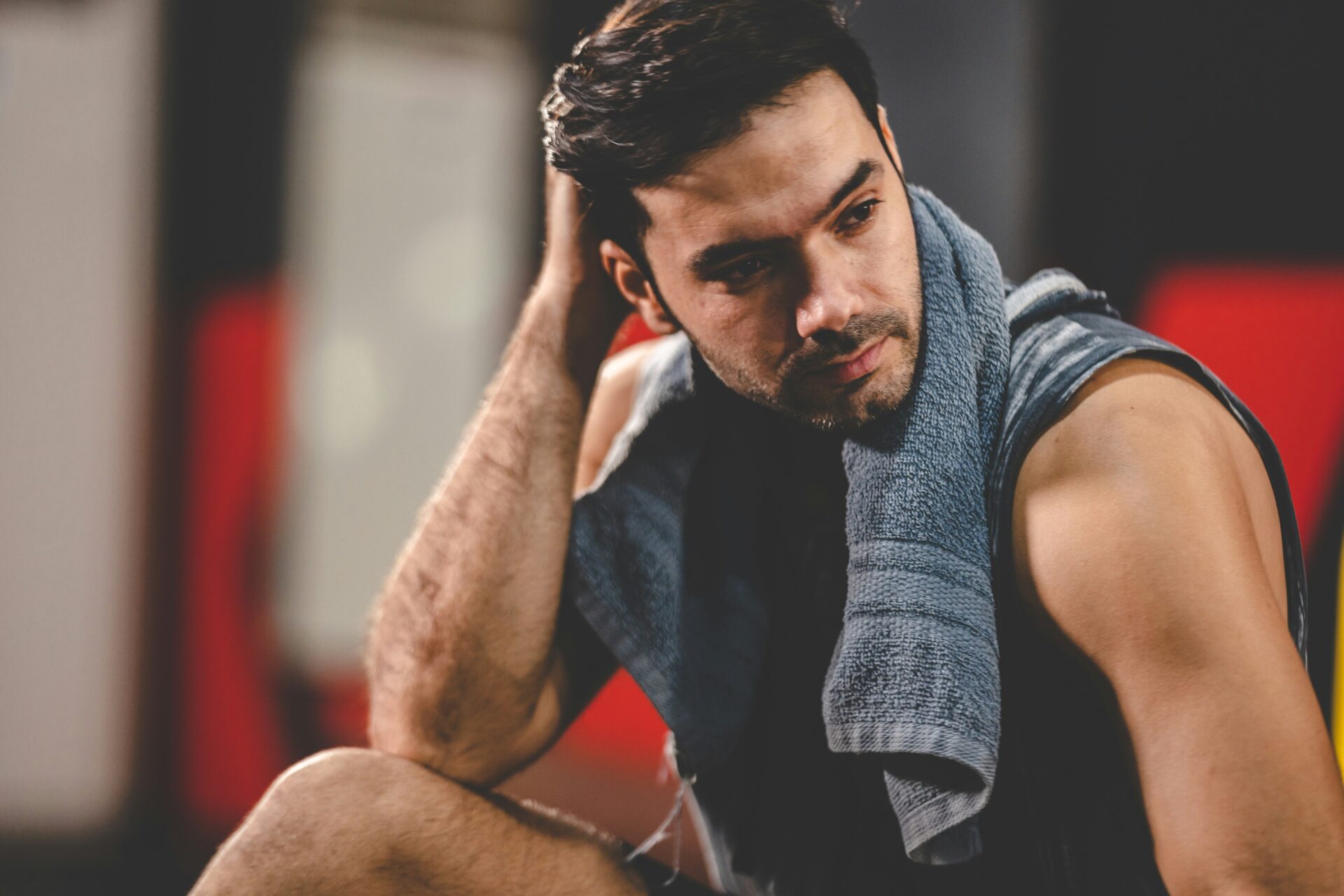 トレーニングジムで頭を触っている男性