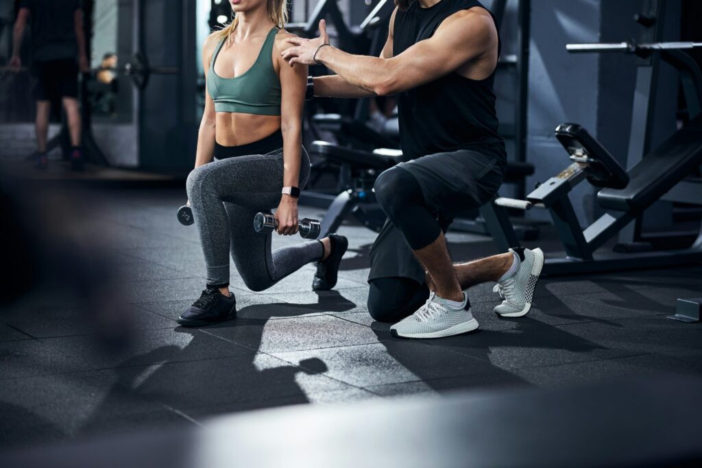 女性にトレーニングを指導している男性インストラクター